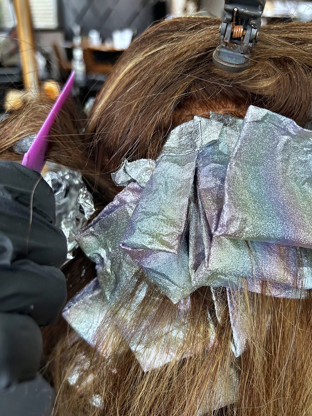 Foils going into a guest's brown hair at Julia Grace, from above.