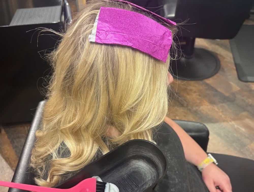 Pink foil going into blonde hair at Julia Grace, with a color brush and gloved hands; no guest face.