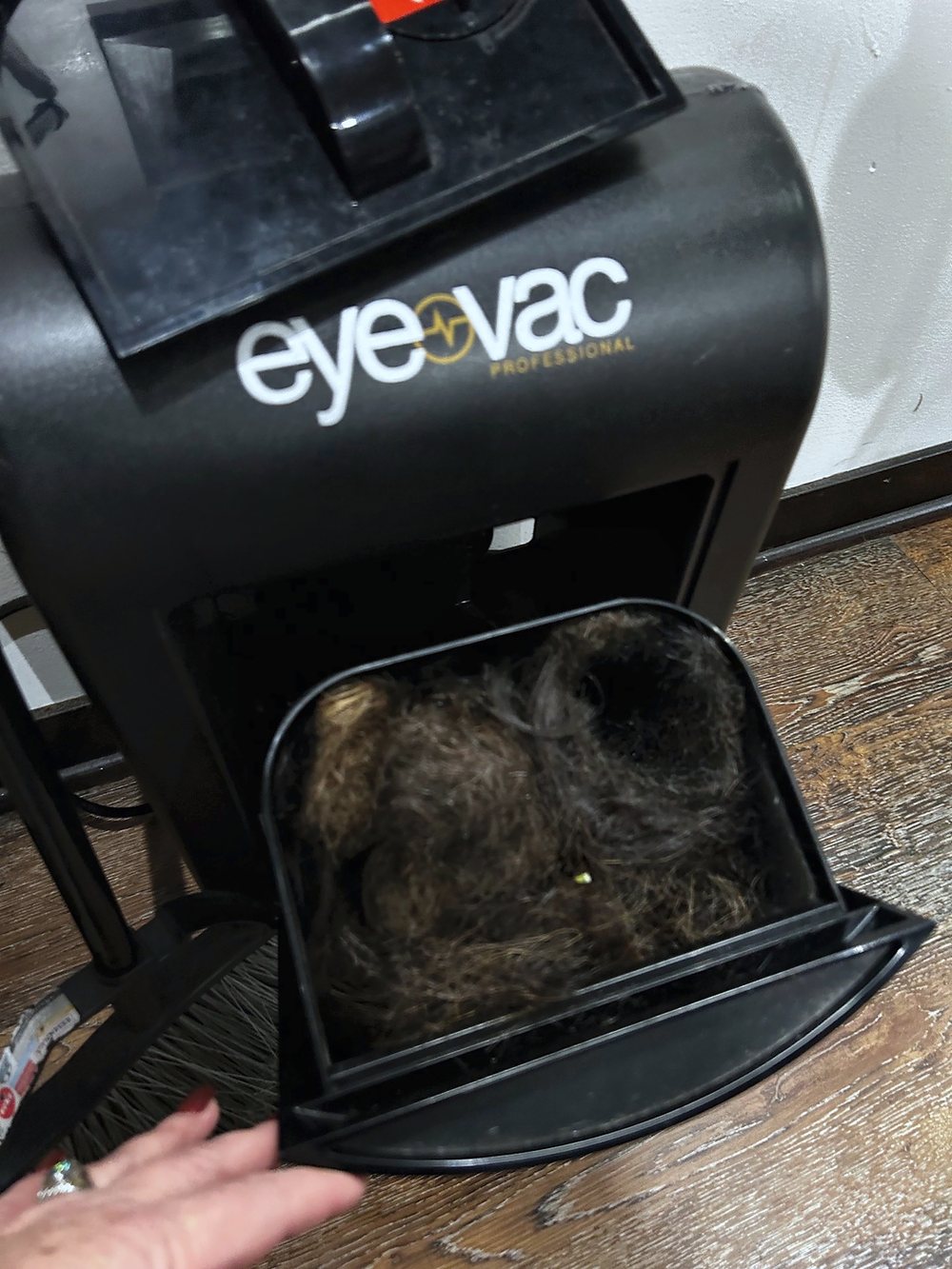 The Eye-Vac's bin pulled open at Julia Grace, full of swept hair.