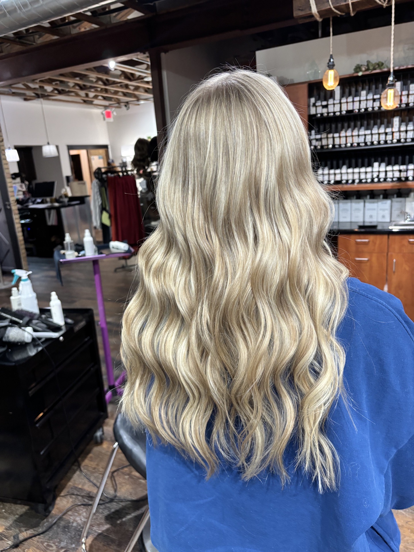 Long platinum waves, shot from behind in the salon
